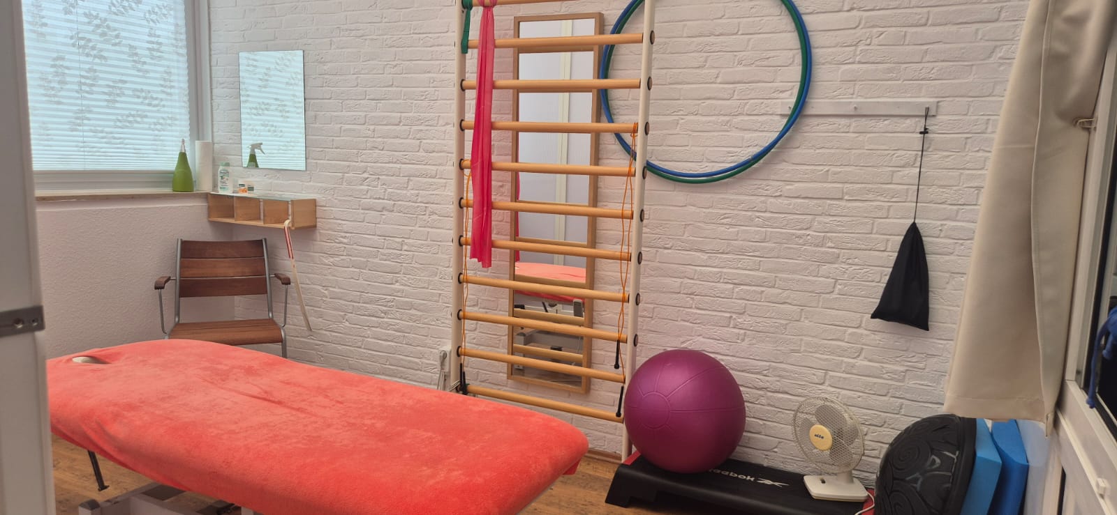 Behandlungsraum mit Sprossenwand und Therapieliege
